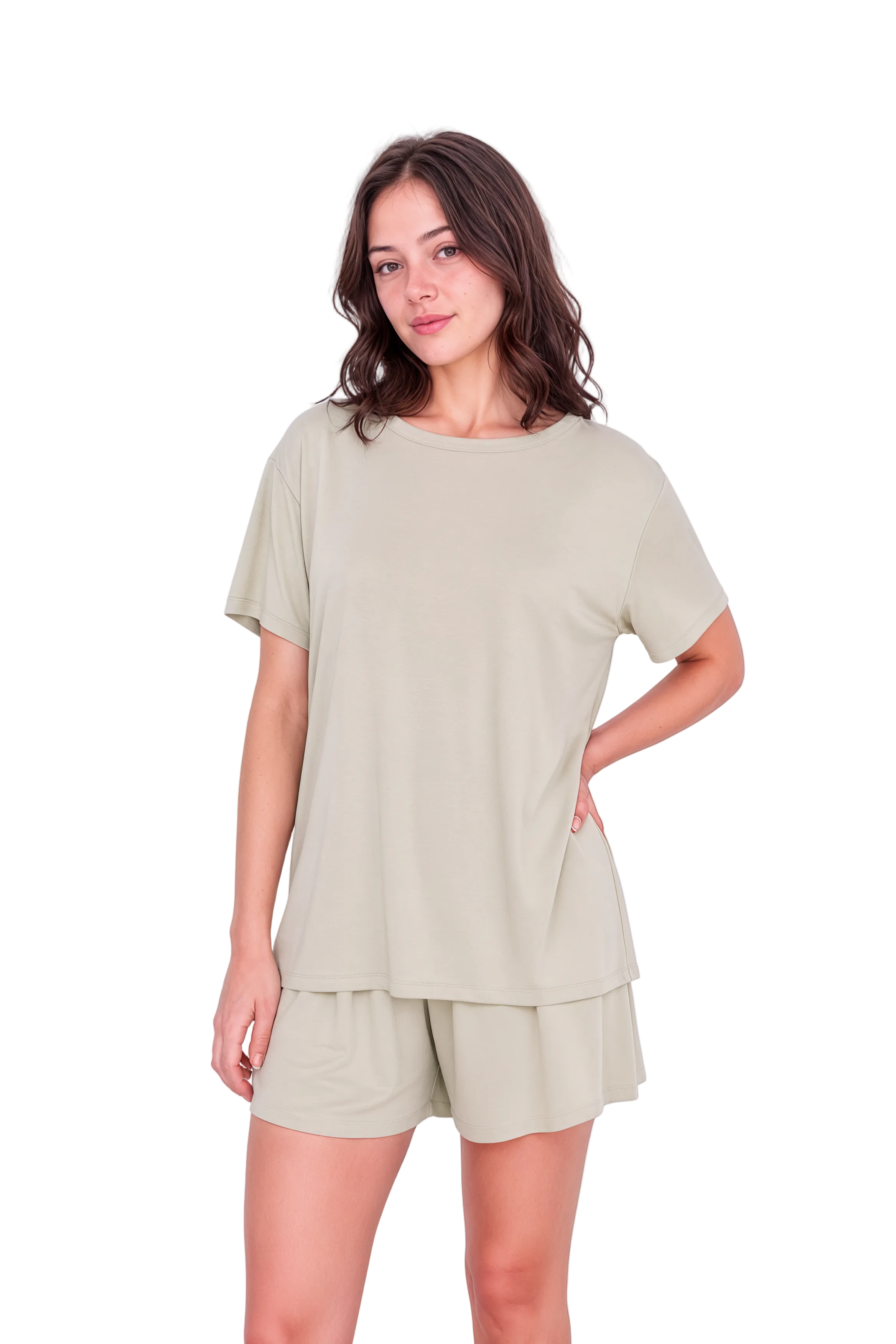 A woman modeling a matching two-piece lounge set consisting of a short-sleeve top and shorts in a light sage green color, set against a plain light pink studio background.