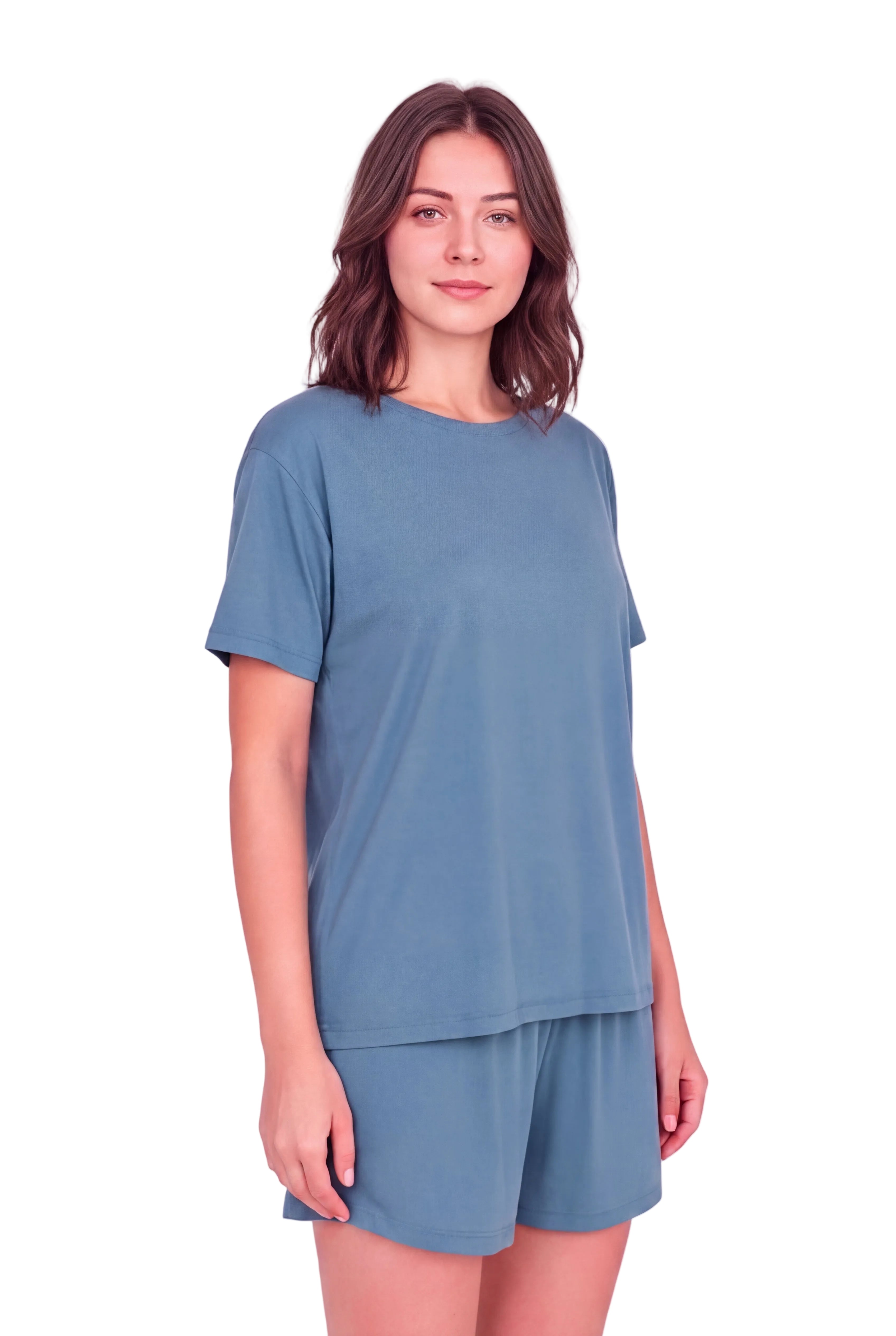 A woman modeling a matching dusty blue lounge set consisting of a short-sleeve crewneck t-shirt and matching shorts, set against a solid pale pink studio background.